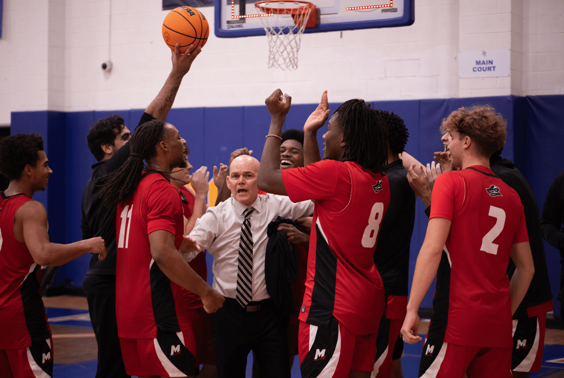 Coach Todd Peretz and players under a basketball hoop